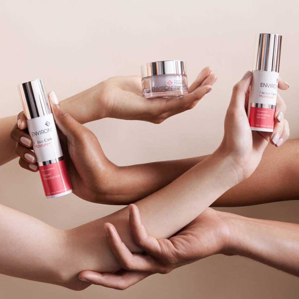 Brazos entrelazados con productos de hidratación intensa de Environ Skincare para el cuidado de la piel en invierno